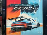 a framed picture of a porsche gt3 poster in a garage