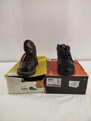 two pairs of black work boots sitting on top of a box