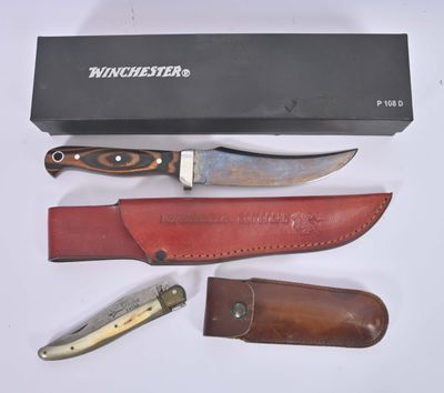a knife, knife sharper, and sheath on a table