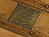 a plaque on the side of a wooden bench