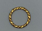 gros plan d'une bague en or sur une surface grise