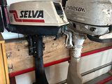 deux moteurs hors-bord posés sur une palette dans un garage