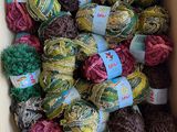 une boîte remplie de nombreuses pelotes de laine de différentes couleurs