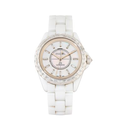 un gros plan d'une montre en céramique blanche dotée d'une lunette sertie de diamants