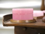 a pink container sitting on top of a wooden table