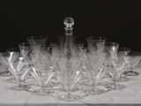 de nombreux verres à vin et une carafe posés sur une table