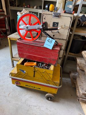une roue rouge sur un chariot jaune dans un garage
