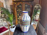 a vase that is sitting on a table in front of a mirror