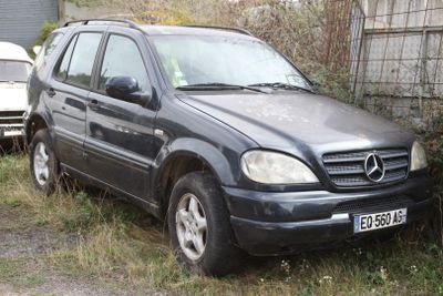 a car that is parked in the grass by a fence
