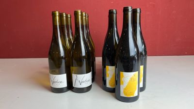 trois bouteilles de vin sont alignées sur une table