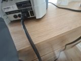 a radio that is on a wooden table with a black cord