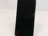 a black cell phone sitting on a stand on a table