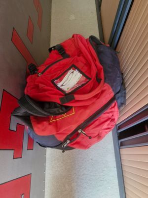 a red backpack sitting on the floor next to a door