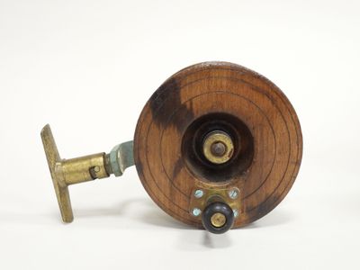 a small wooden fishing reel with a metal spool