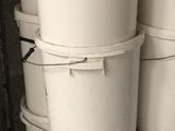 several white buckets stacked on top of each other in a garage
