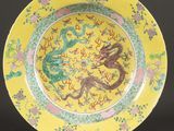 une image représentant une assiette jaune ornée d'un dragon et de fleurs