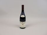 the bottle of wine is sitting on a white surface