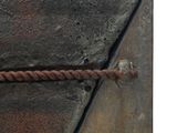a rusted metal object with a rusted chain on it