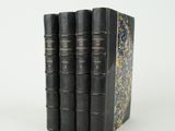 trois livres superposés sur une surface blanche