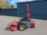 a red riding lawn mower parked in a parking lot