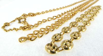 a close up of three gold chains on a white surface