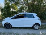 a white car parked on a dirt road in front of trees