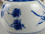 a blue and white tea pot with a bamboo handle