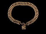 un bracelet en or orné d'une breloque en forme de trèfle