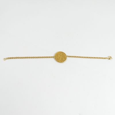 a gold bracelet with a coin on a chain
