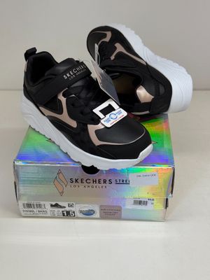 black and pink sneakers with white soles on top of a box