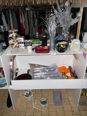 une étagère blanche sur laquelle sont posés tout un tas d'objets