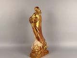 gold statue of a woman holding a baby in her arms
