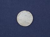 a close up of a silver coin on a blue cloth
