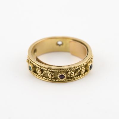 un gros plan d'une bague en or sertie de pierres noires