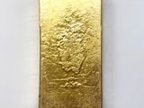 a close up of a gold bar on a white surface