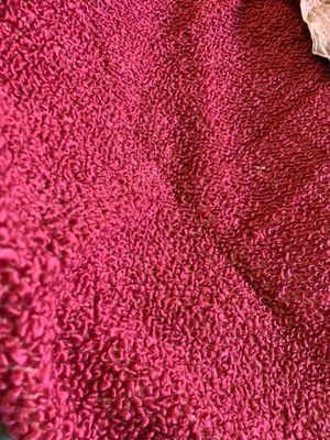 a cat that is laying on a red towel