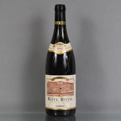 une vieille bouteille de vin posée sur une table en verre