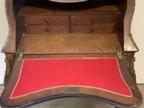 a wooden desk with a red cushion on it