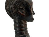 a wooden sculpture of a woman with a hat on her head