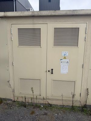 deux portes situées sur le côté d'un immeuble sur lequel est accrochée une enseigne