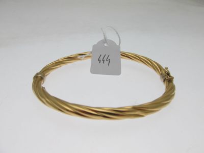 a close up of a gold plated wire bracelet with a price tag