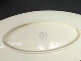 a white plate with a crest on it sitting on a table