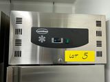 une photo d'un réfrigérateur en acier inoxydable recouvert de nombreux aimants