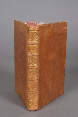 an old book sitting on top of a table next to a gray wall