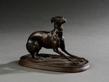 statue en bronze représentant un chien, posée sur un socle en bois, sur une surface grise