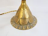 a gold lamp that is sitting on a white table