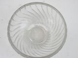 a clear glass bowl with a silver lid on a white table