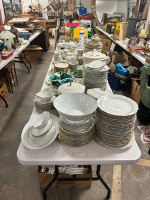 une longue table sur laquelle sont disposées de nombreuses assiettes et bols