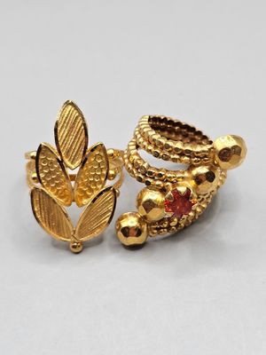 a close up of a pair of gold rings with red stones
