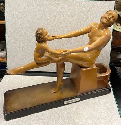 une statue représentant un homme et une femme assis sur un banc